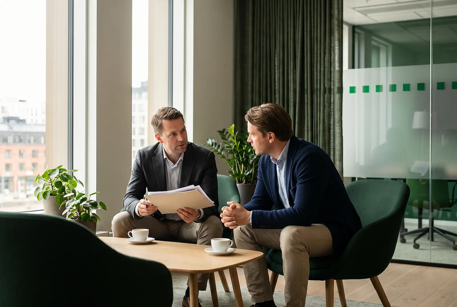 Zwei Kollegen sprechen in der Büro-Lounge über die Vorteile einer betrieblichen Krankenversicherung für PKV-Kunden